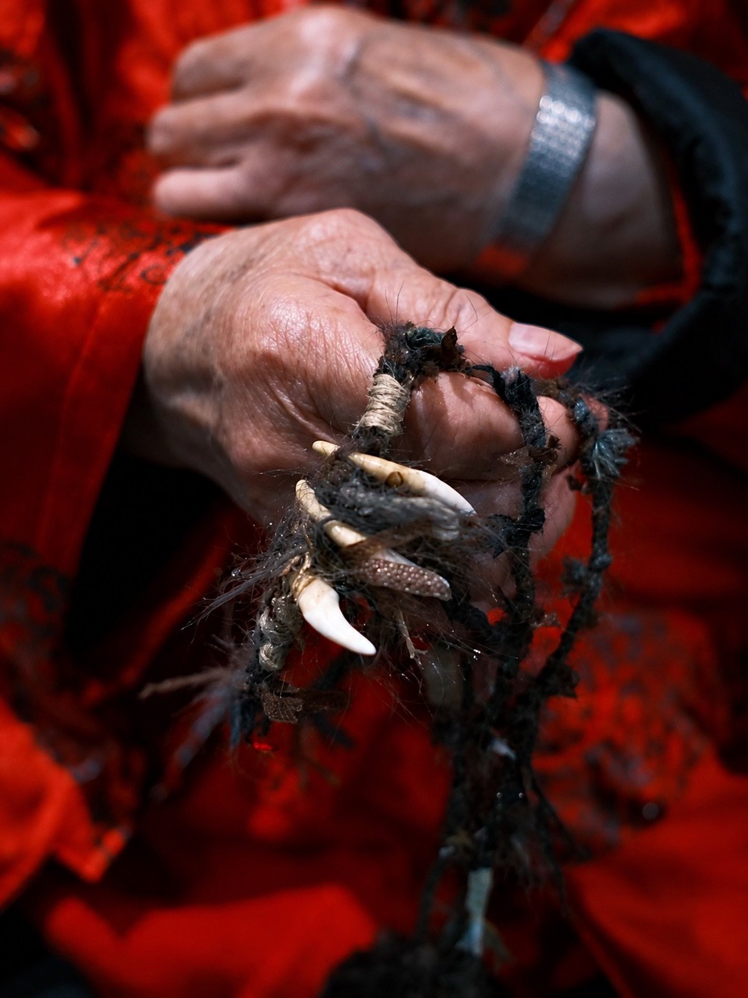 Small aged objects and cord held in a hand
