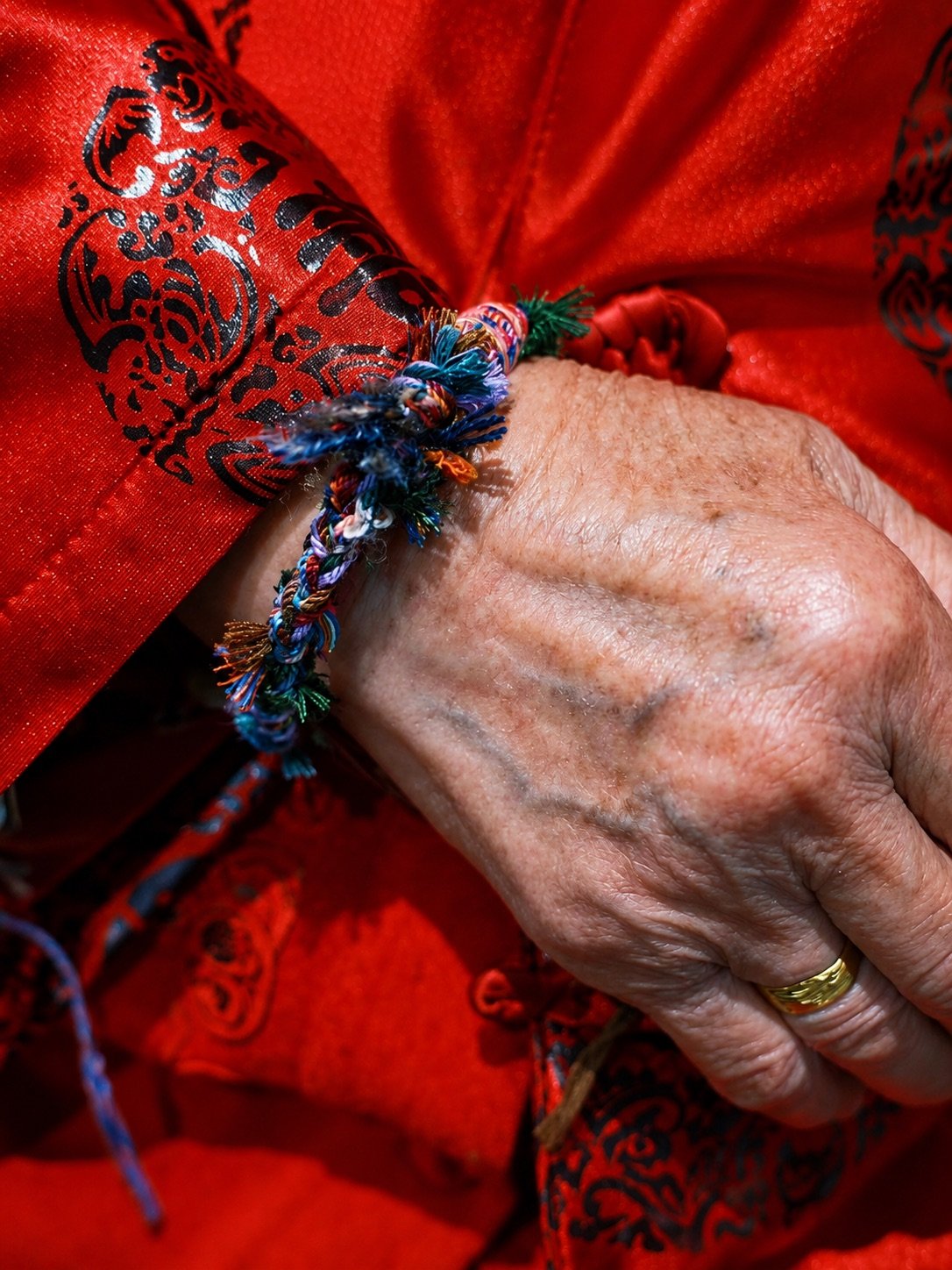 A colourful handmade cord bracelet worn on a wrist