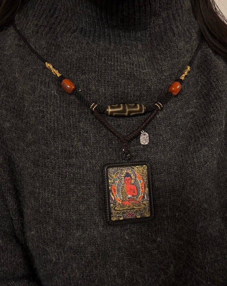 A one-of-one handmade necklace worn over a dark knit