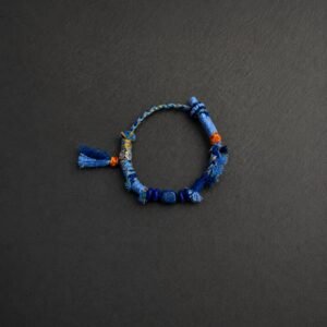 LHARI Blue Kora Protection Bracelet black background overhead view