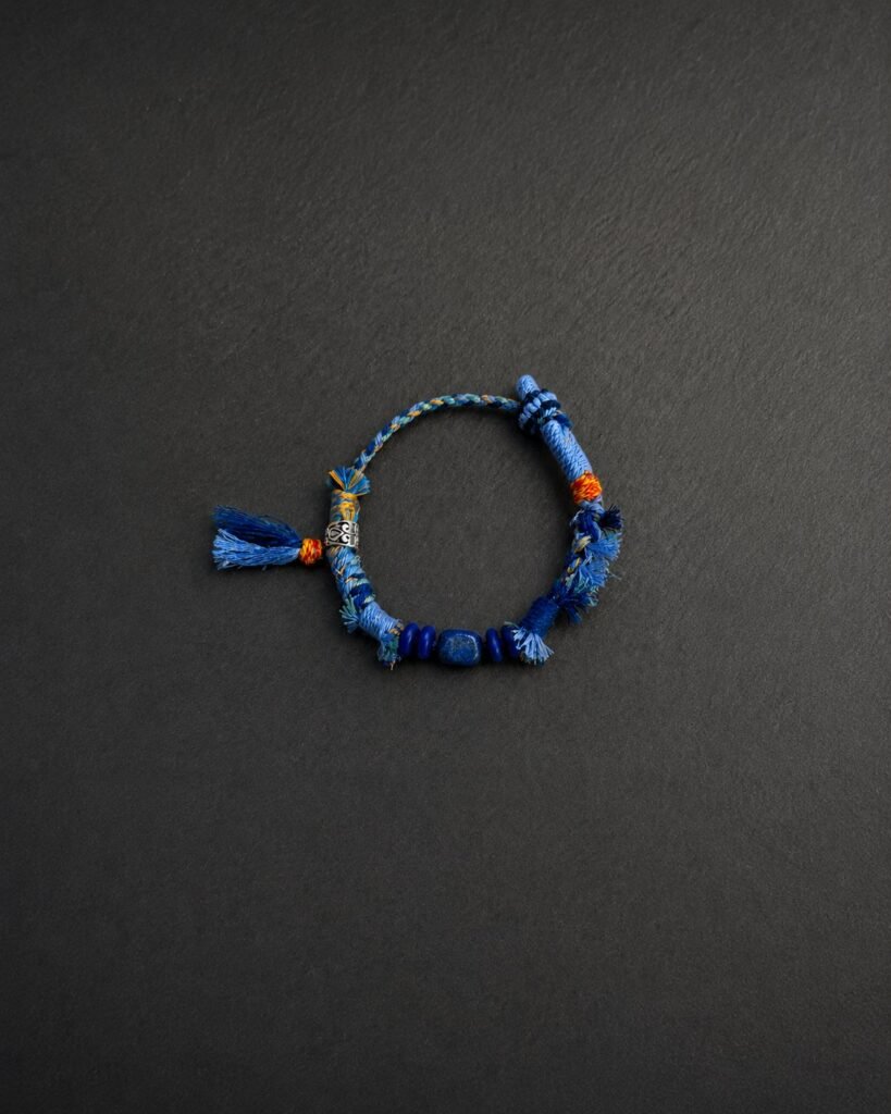 LHARI Blue Kora Protection Bracelet black background overhead view
