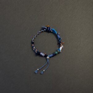 LHARI Blue Wind Prayer Cord Bracelet black background overhead view
