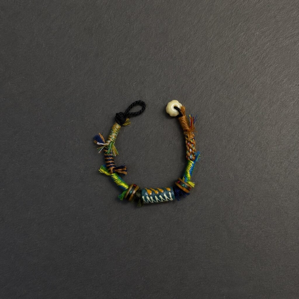 LHARI Kora Wind Protection Bracelet black background overhead view