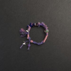 LHARI Lilac Butterfly Prayer Cord Bracelet black background overhead view
