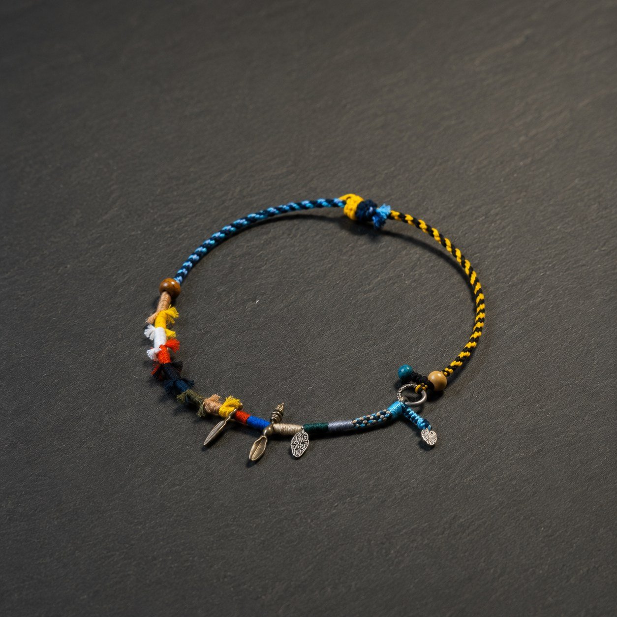 LHARI Wind Prayer Cord Necklace black background 45-degree view